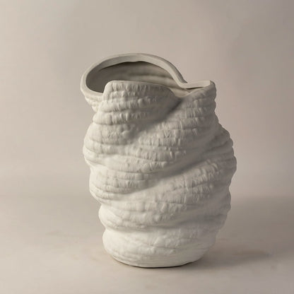 Side angle view of white ceramic sculptural vase with unique textured surface and curved rim ideal for modern home interiors.