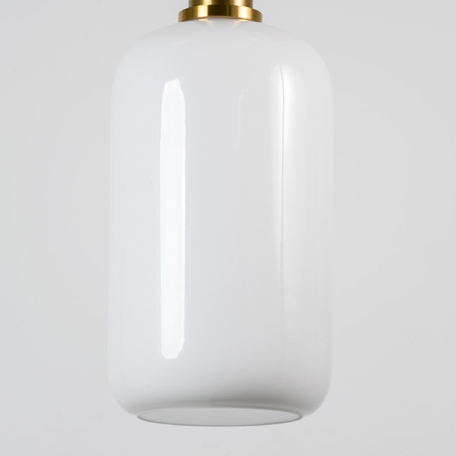 White glass pendant light with brass metal fixture showcasing smooth glossy finish and refined contemporary lighting style.