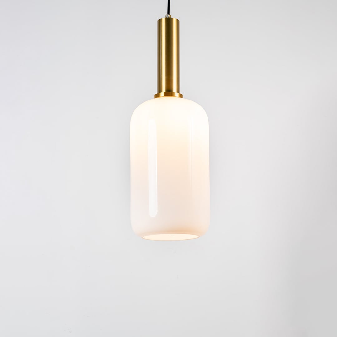 White glass pendant light with brass metal holder and minimalist cylindrical design for elegant ceiling lighting decor.