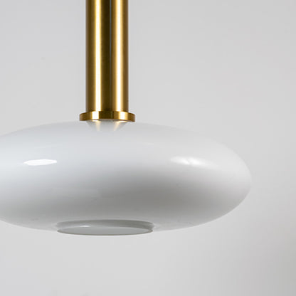 White glass pendant light with brass metal fixture showcasing smooth glossy finish and refined modern lighting style.