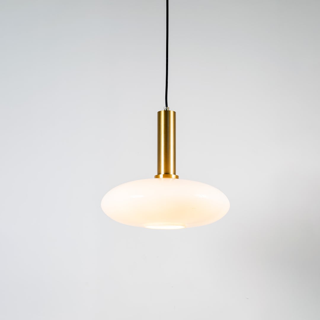 White glass pendant light with brass metal holder and modern disc design for elegant contemporary ceiling lighting decor.