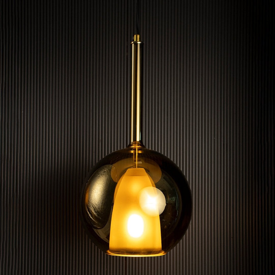 Amber pendant light glowing against dark background highlighting its rich amber glass finish and warm tone.