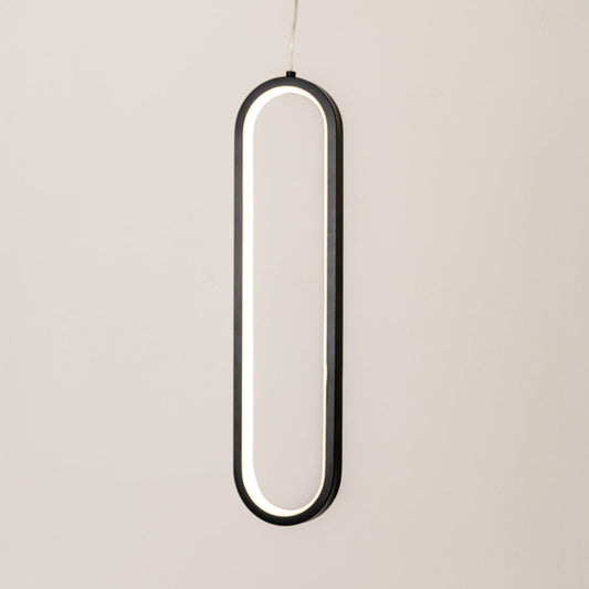 Modern metal elongated loop hanging light in black and white glowing softly on white background for stylish wall decor.