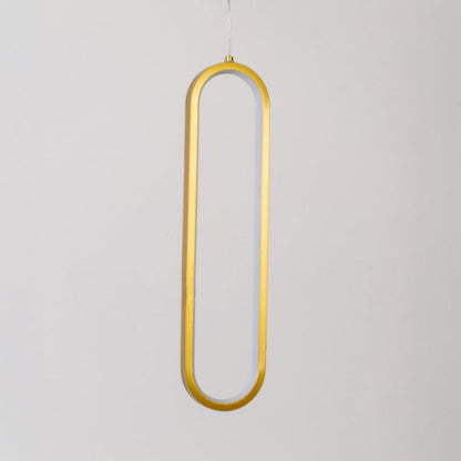 Modern metal elongated loop hanging light in gold shown switched off on white background for minimal wall decor.