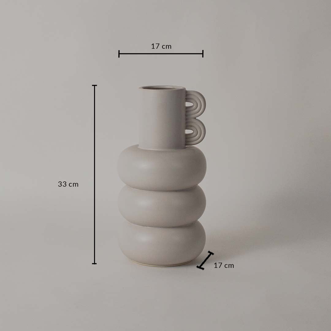 A sculptural neutral vase shown on a white background with clear dimension markings displaying 33 cm height 17 cm top width and 17 cm base width.