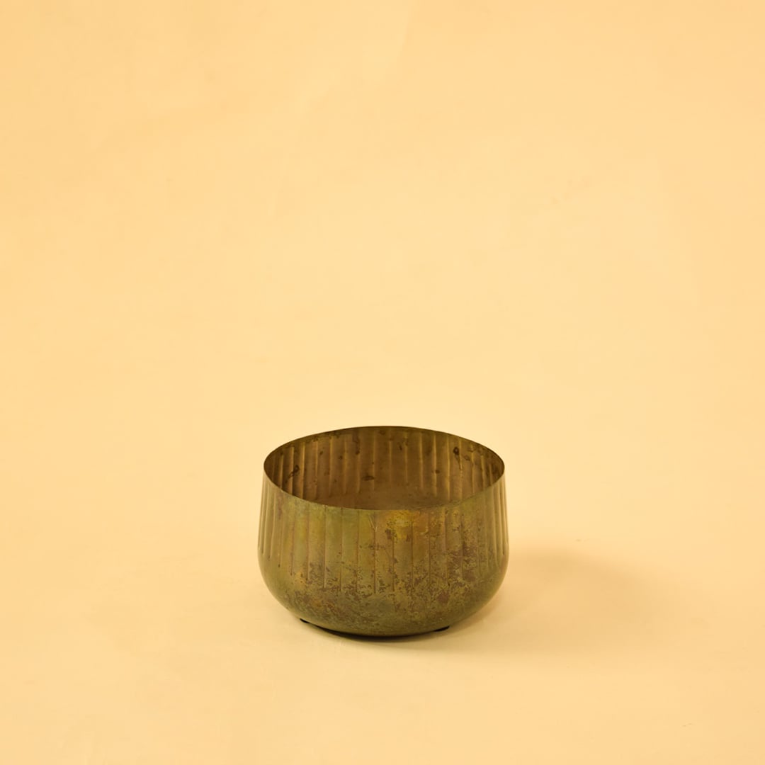 Bronze ribbed metal bowl planter on clean white background perfect for shelves tables and simple modern home decor.