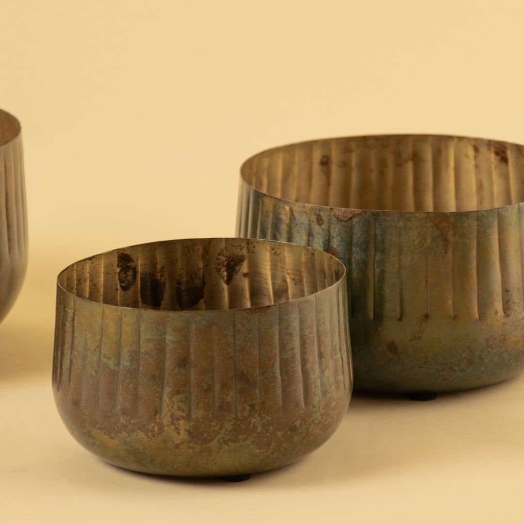 Ribbed metal bowl planter closeup showing textured ribbed detailing with a warm rustic finish.