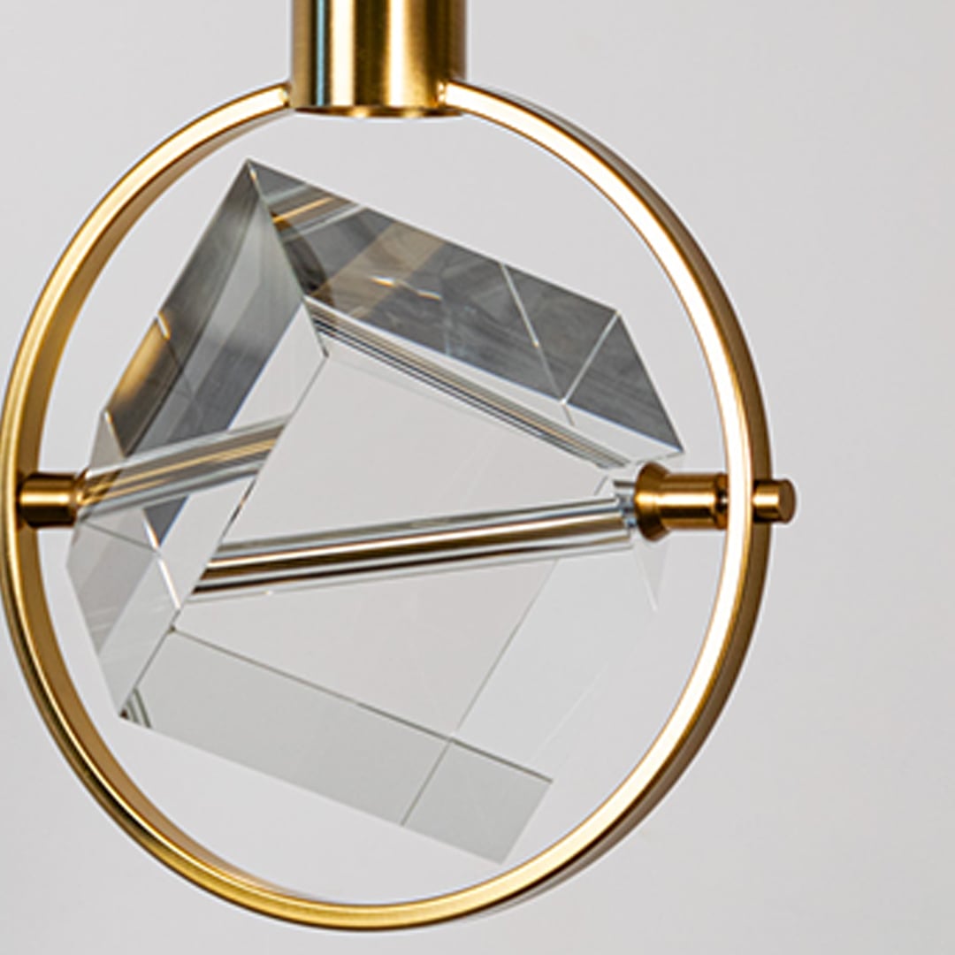 Closeup of crystal pendant light with golden circular frame and cube design perfect for luxury modern interiors.