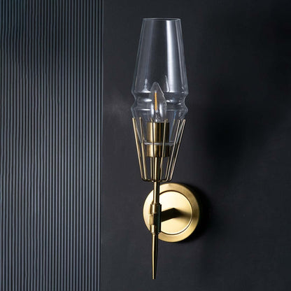 Sleek unlit wall lamp with brass cage detail and clear glass shade shown on black background showcasing premium metal finish and quality.