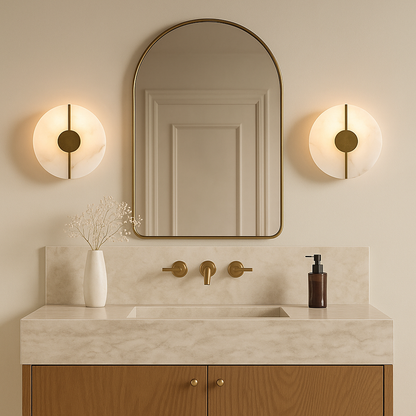 Round wall lights with gold accents illuminate a modern bathroom featuring a marble vanity arched mirror and warm minimal aesthetic.