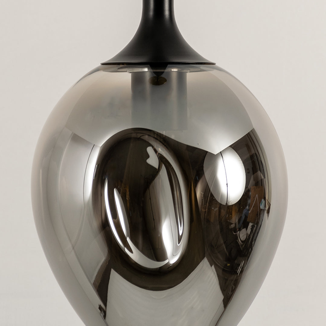 Close up chrome pendant light with reflective metallic finish modern decorative hanging light for contemporary interiors.
