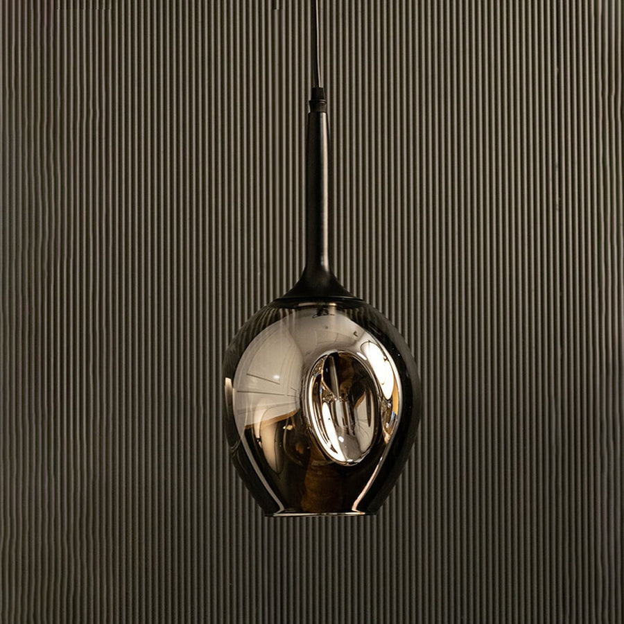Chrome pendant light off against black background for modern luxury home decor.