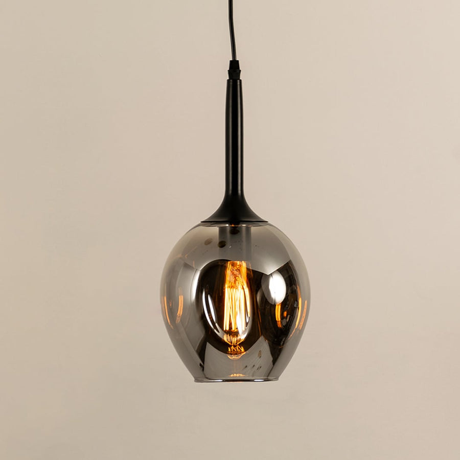 Closeup of smoked amber glass pendant light with black finish showcasing premium craftsmanship and texture.