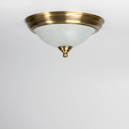 Modern antique brass ceiling light with frosted glass diffuser for stylish bedroom and traditional home decor spaces.