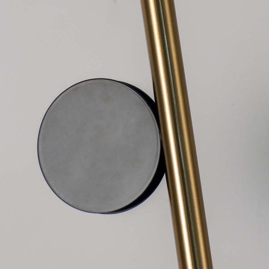 Closeup of gold tubular pendant light with circular glass detail sleek ceiling lamp for luxury bedroom and living room lighting.