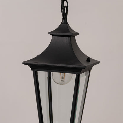 Closeup outdoor lantern in black metal finish with glass panels for garden or entrance decor lighting white background.