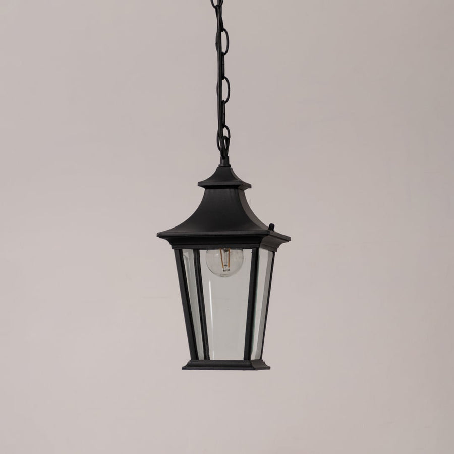 Black metal hanging lantern with clear glass panels displayed on a white background with the light switched off.