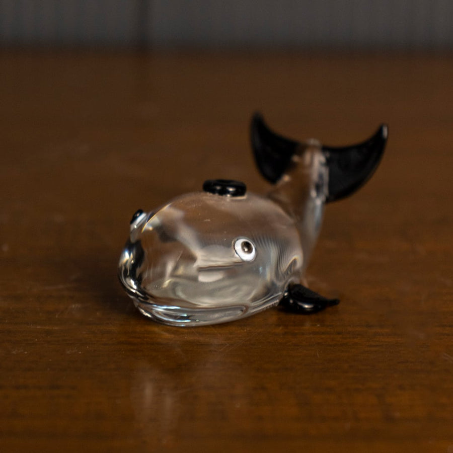 Artistic glass dolphin figurine with shiny black fins highlighted on dark background for luxury home decor.