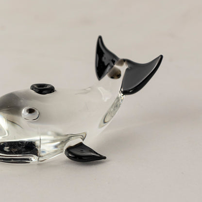 Black and white glass dog figurine with glossy finish placed on wooden surface against neutral background creating bold modern decorative statement piece.