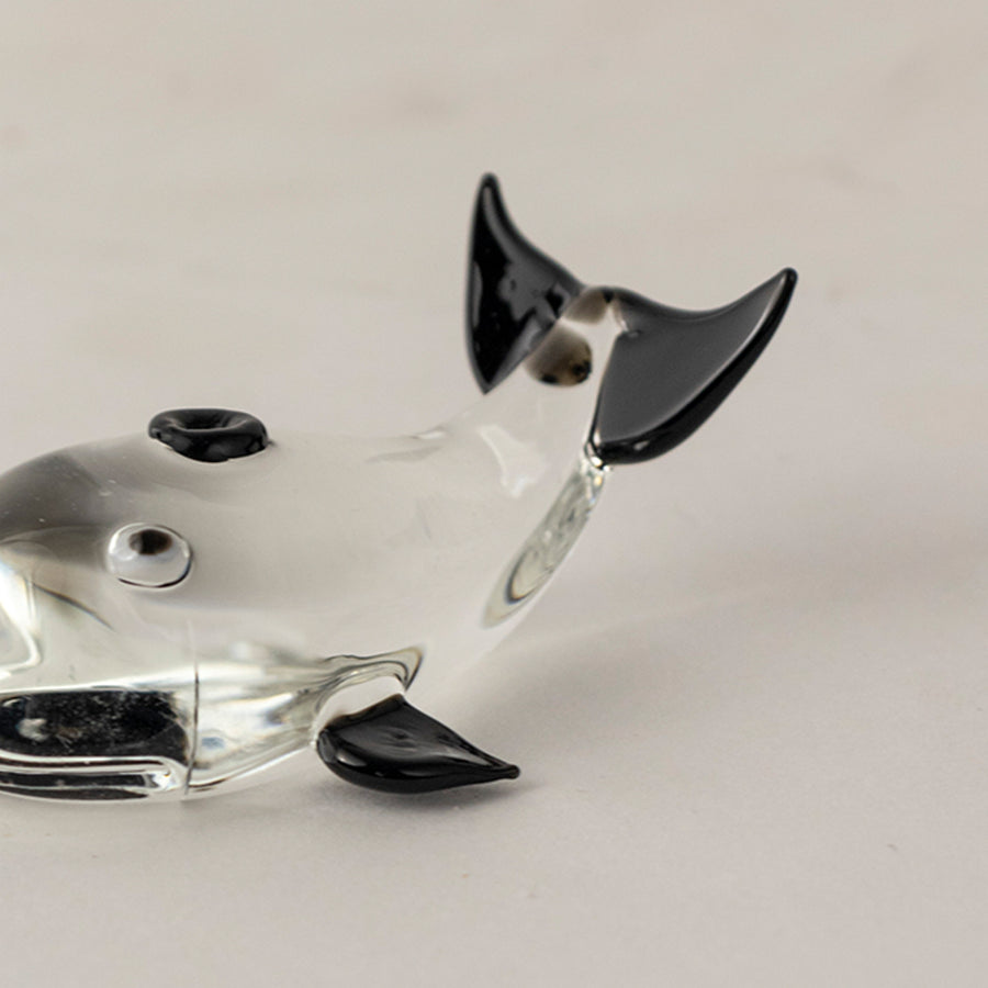 Black and white glass dog figurine with glossy finish placed on wooden surface against neutral background creating bold modern decorative statement piece.