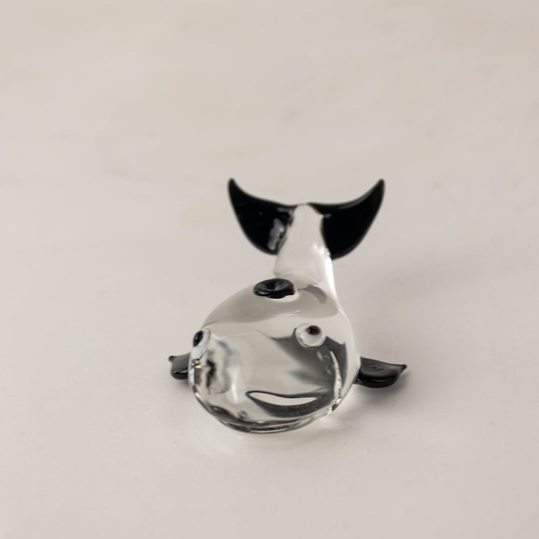 Handcrafted clear glass dolphin figurine with sleek finish ideal for tabletop display and marine themed decor.