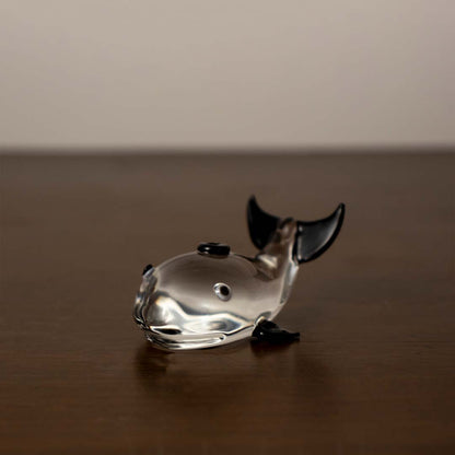 Clear glass dolphin showpiece with black detailing placed on white background for modern home decoration.
