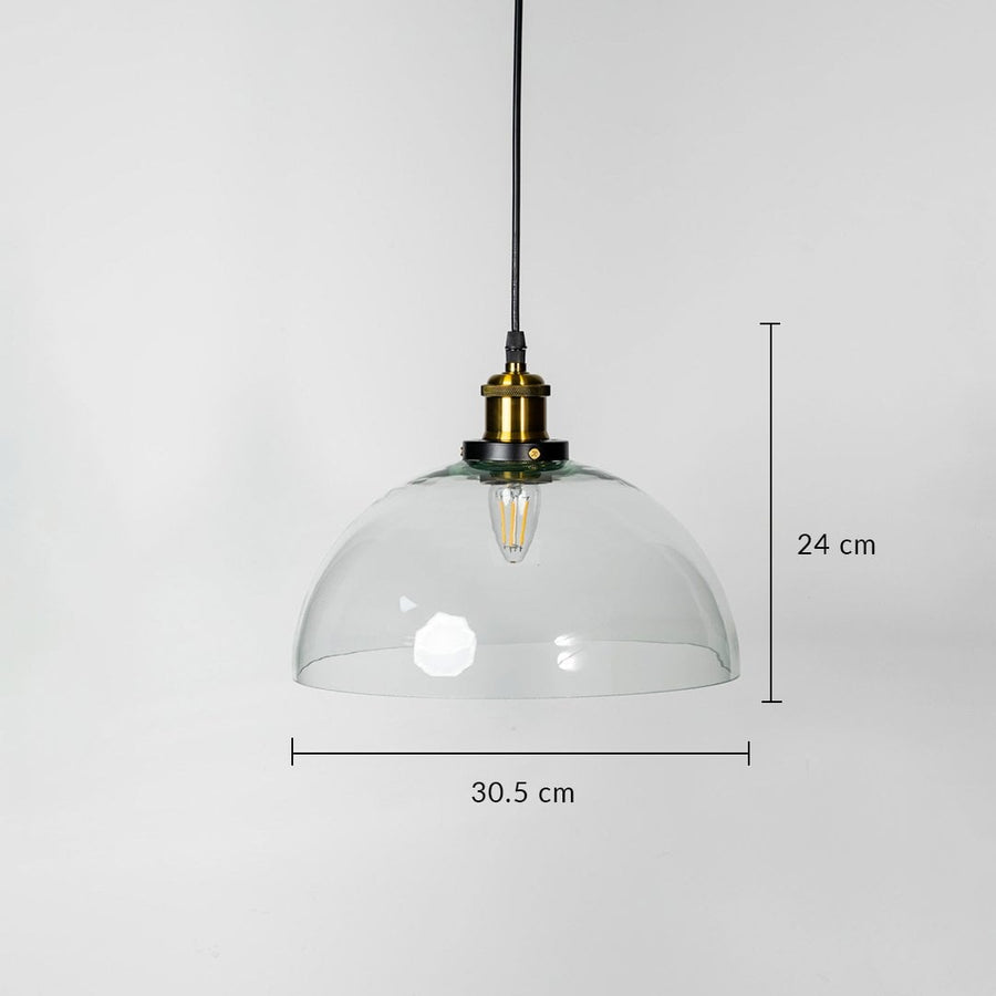 Dome pendant light with clear glass shade brass fitting and black cord shown with 24cm height and 30.5cm width.