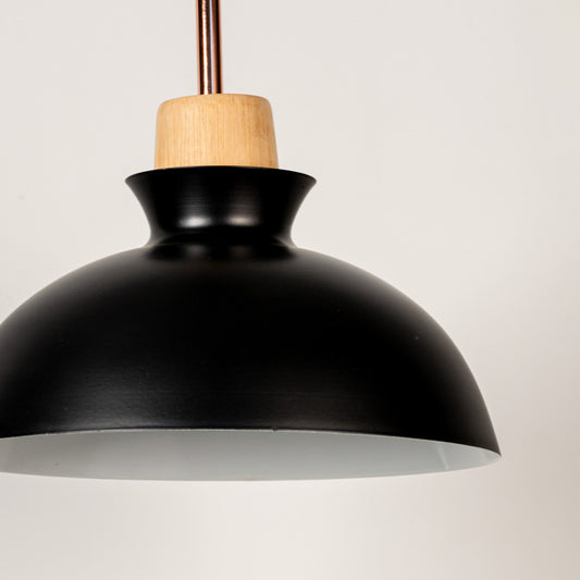 Black metal pendant light with natural wood detailing showcasing smooth dome shape and modern Scandinavian design appeal.