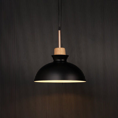 Black dome pendant ceiling light with wood accent illuminated on back background for dining room cafe and modern interior lighting.