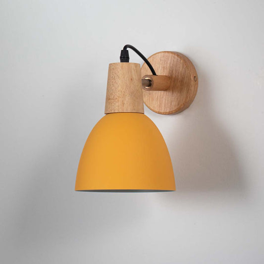 Wall sconce with matte yellow metal shade wooden base and black cord perfect for bedroom living room and hallway walls.