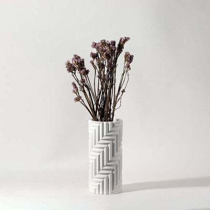 Soft purple dried flowers held in hand against a warm room setting adding rustic natural charm to modern home decor.