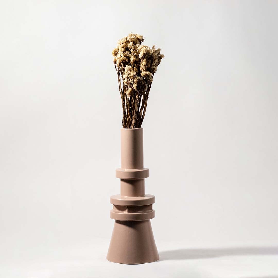 Natural beige dried flowers held in hand against a soft room setting adding rustic organic texture to modern home decor.