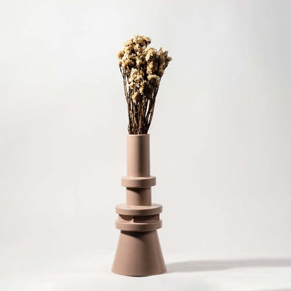 Natural beige dried flowers held in hand against a soft room setting adding rustic organic texture to modern home decor.