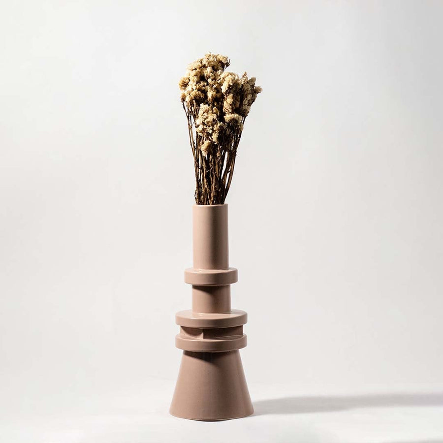 Natural beige dried flowers held in hand against a soft room setting adding rustic organic texture to modern home decor.