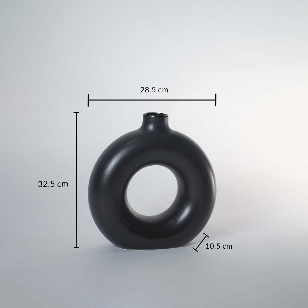 Black ceramic donut vase with matte finish measuring 32.5 cm height 28.5 cm width and 10.5 cm depth for elegant decor.
