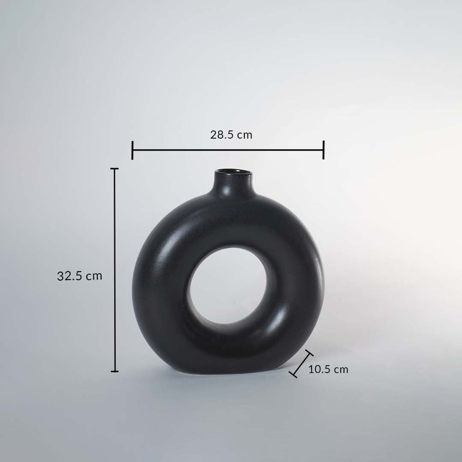 Black ceramic donut vase with matte finish measuring 32.5 cm height 28.5 cm width and 10.5 cm depth for elegant decor.