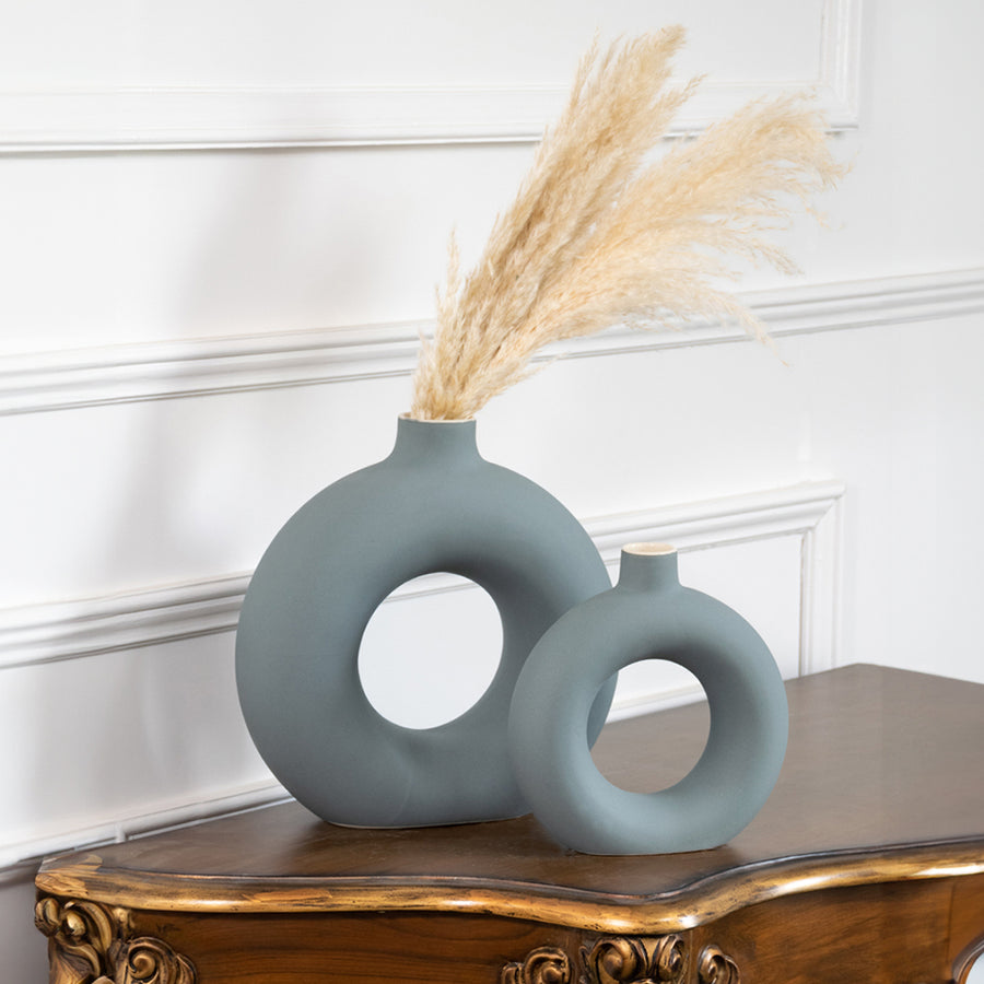 Blue ceramic ring vase set with dried pampas grass on a console table for contemporary home decor styling.