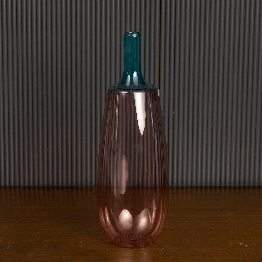 Stylish pink glass vase with blue top highlighted on dark background for luxury home interior styling.