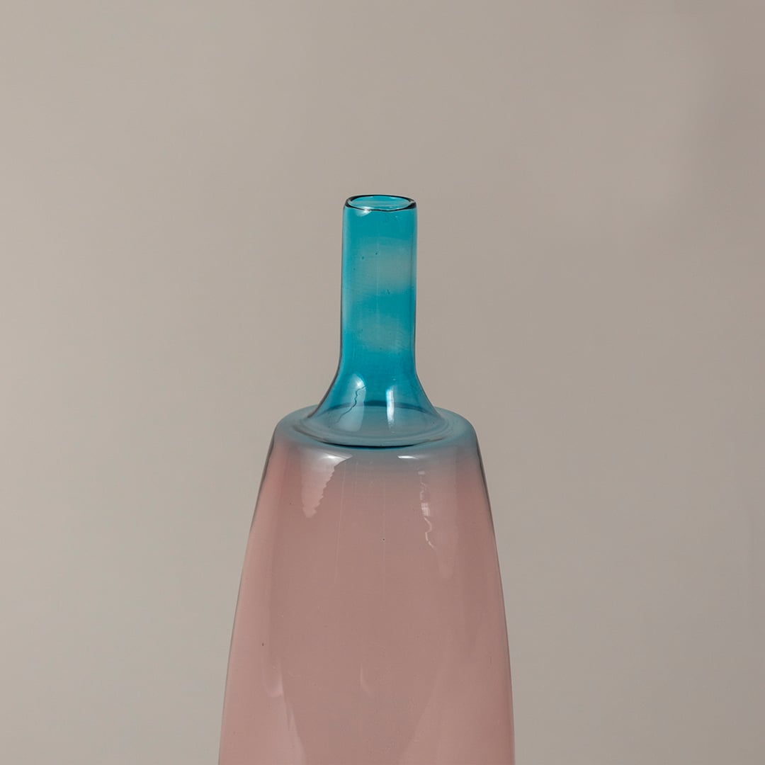 Closeup of handcrafted pink and blue glass vase showing sleek gradient finish and artistic smooth texture.