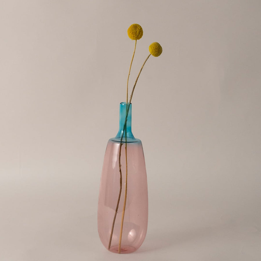 Decorative pink blue glass vase placed on tabletop for elegant modern home and dining room decoration.