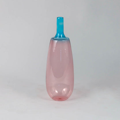 Transparent pink glass vase with blue neck ideal for flower arrangements and modern shelf decoration.
