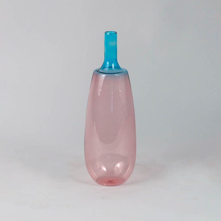 Transparent pink glass vase with blue neck ideal for flower arrangements and modern shelf decoration.
