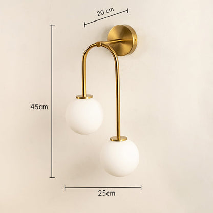 Gold metal wall light with dual white glass globes showing 45 cm height and 15 cm width dimensions for interior wall mounting.