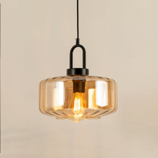 Amber glass pendant light with a faceted shade glowing warmly and creating a soft modern accent that enhances the room with a subtle contemporary decorative presence.