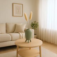 Dried billy buttons and pampas grass arranged in a green vase creating a floral décor accent ideal for modern boho décor and natural warm interior styling.