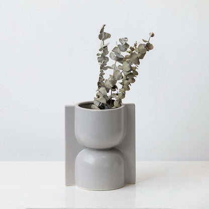 Dried eucalyptus leaves arranged in a geometric grey vase ideal for minimalist home décor and calming natural interior styling.