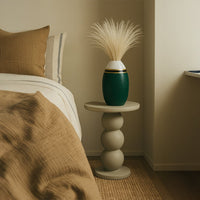 White pampas grass stems styled in green ceramic vase on bedside table adding natural boho charm to modern bedroom decor.