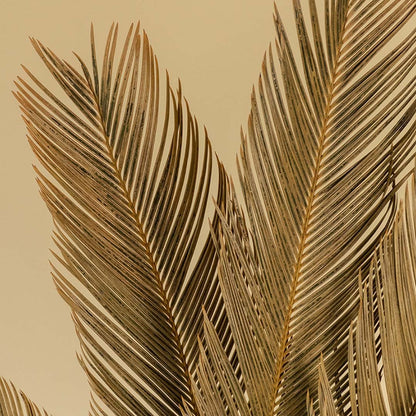 Closeup view of golden dried palm leaves showing fine texture and natural finish for modern interior decoration.