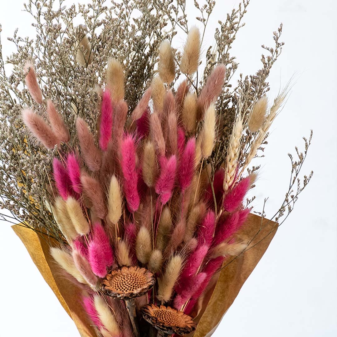 Preserved dried flower bouquet with pink bunny tail grass and natural fillers styled for home decor display.