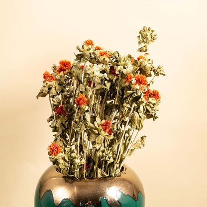 Closeup of green ceramic vase with gold accent showcasing glossy surface and dried orange flowers adding rich detail for elegant home decor styling.